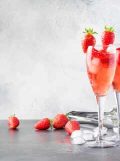 Strawberry Prosecco Cocktail.Rossini alcoholic cocktail with Italian sparkling wine, strawberry puree and ice in champagne glasses, place for text, selective focus
